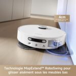Un robot aspirateur blanc est placé sur un sol en bois, avec des indications sur sa technologie permettant de nettoyer sous les meubles bas.